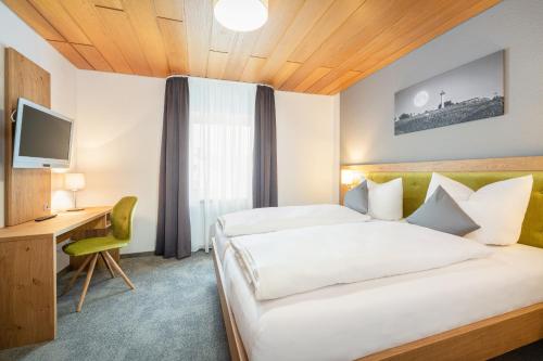 a hotel room with a bed and a desk at Die Landpension FernW in Willingen