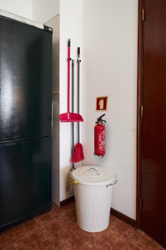 a kitchen with a black refrigerator and a trash can at apart@CostaSantoAndré Beach in Santiago do Cacém