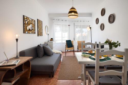 a living room with a couch and a table at apart@CostaSantoAndré Beach in Santiago do Cacém