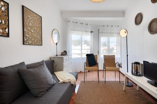 a living room with a couch and a desk at apart@CostaSantoAndré Beach in Santiago do Cacém