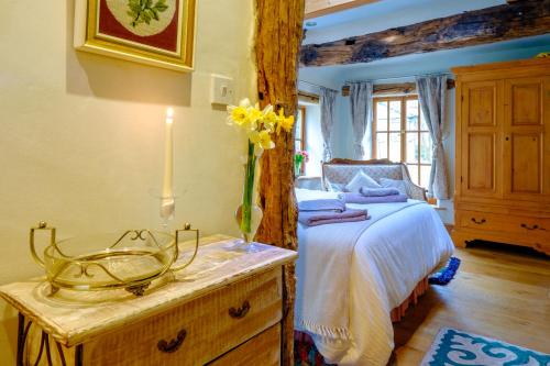 Sunnyside Bed and Breakfast في Longnor: غرفة نوم مع سرير و مزهرية من الزهور على طاولة