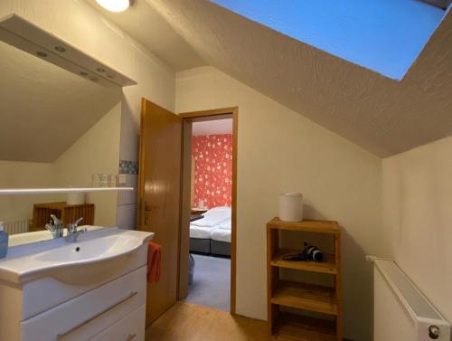 baño con lavabo y habitación con cama en Apartments Starlight Hotel Wiesmann, en Bochum