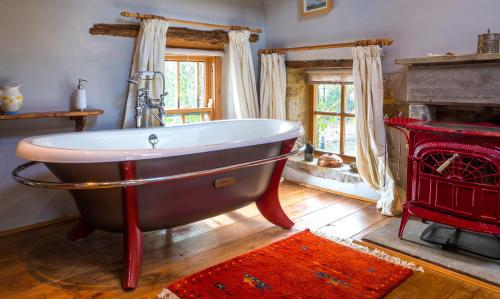 Longnor的住宿－Sunnyside Bed and Breakfast，带壁炉的客房内设有浴缸。