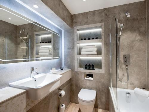 uma casa de banho com um lavatório, um chuveiro e um WC. em Clandeboye Lodge Hotel em Bangor