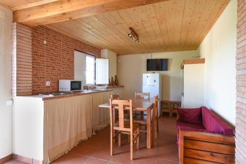 a kitchen and living room with a table and chairs at Montinho Do Cerro Alto in Cercal