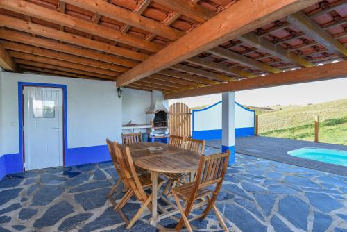 a dining room with a table and chairs on a patio at Montinho Do Cerro Alto in Cercal