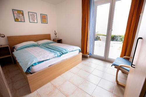 a bedroom with a bed and a sliding glass door at Apartma Categorical in Portorož