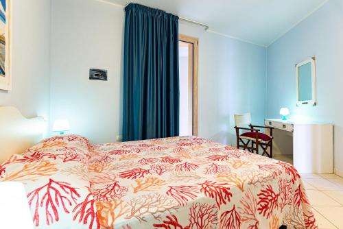 1 dormitorio con 1 cama con colcha colorida en La Pergola al Cavo 5, en Cavo