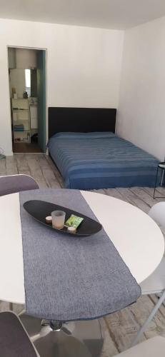 Cette chambre comprend un lit et une table avec une plaque de cuisson. dans l'établissement Un Studio Premium tout à nouveau rénové, centre ville, à Béziers