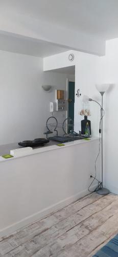 une cuisine avec des murs blancs et une table avec une lampe dans l'établissement Un Studio Premium tout à nouveau rénové, centre ville, à Béziers