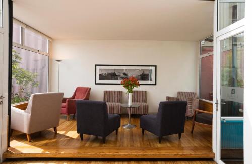 a living room with chairs and a table with a vase of flowers at Hotel Ultramar in Valparaíso