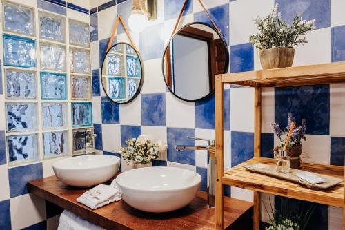 a bathroom with two sinks and a mirror at Casa Rural El Puente Grande in Navahermosa