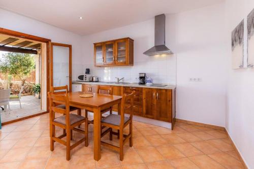a kitchen with a wooden table and chairs in it at S'Hort Can Capità in Ariany