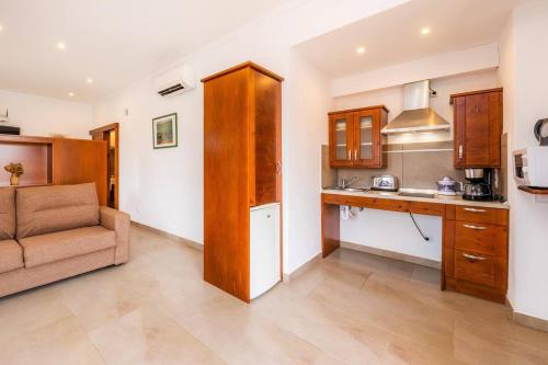 a living room with a couch and a kitchen at S'Hort Can Capità in Ariany