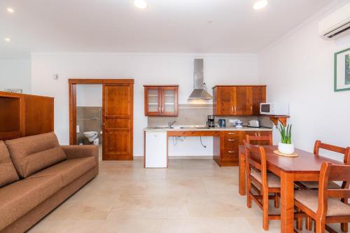 a kitchen and living room with a couch and a table at S'Hort Can Capità in Ariany