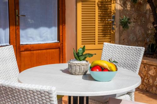a white table with a bowl of fruit on it at S'Hort Can Capità in Ariany