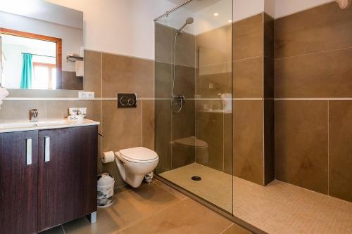 a bathroom with a toilet and a glass shower at S'Hort Can Capità in Ariany