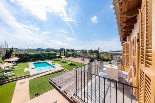 a balcony with a view of a garden and a swimming pool at S'Hort Can Capità in Ariany