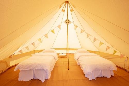 a room with three beds in a tent at Nine Yards Bell Tents at the TT in Castletown