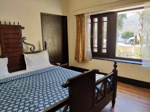 sypialnia z łóżkiem i oknem w obiekcie The Fateh Hotel by Le Pension Stays w mieście Udaipur