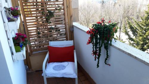 balkon z czerwoną poduszką, krzesłem i oknem w obiekcie My b&b - Strada Vecchia del Pinocchio 3/B w mieście Ancona