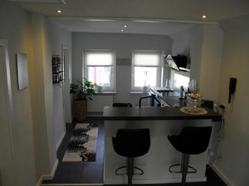 a kitchen with a counter and two bar stools at Altstadtwohnung in Verden