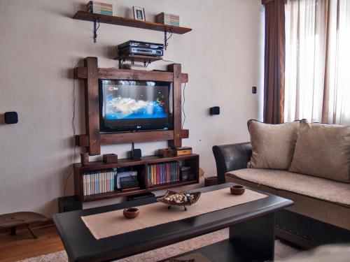 a living room with a couch and a tv at Holiday Home Drijenak in Kolašin
