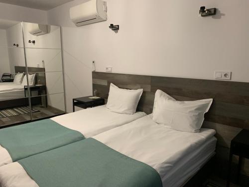 um quarto de hotel com duas camas e um espelho em ARTE Hotel rooms & apartments em Veliko Tŭrnovo