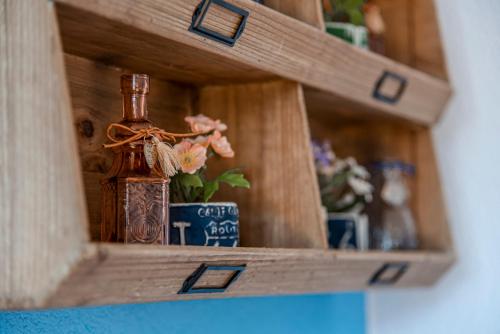 a wooden shelf with a bottle and flowers in it at Pension Sixtysix in Zandvoort