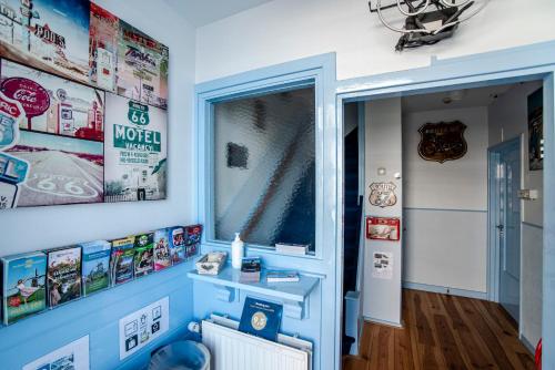 una habitación con una pared azul con carteles en la pared en Pension Sixtysix, en Zandvoort