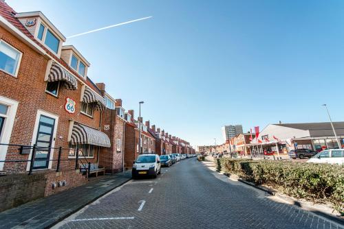 eine Straße mit Autos, die an der Seite eines Gebäudes geparkt sind in der Unterkunft Pension Sixtysix in Zandvoort