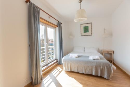 a bedroom with a bed and a large window at Spacious Beach Flat in Costa Caparica by Soulplaces in Costa da Caparica