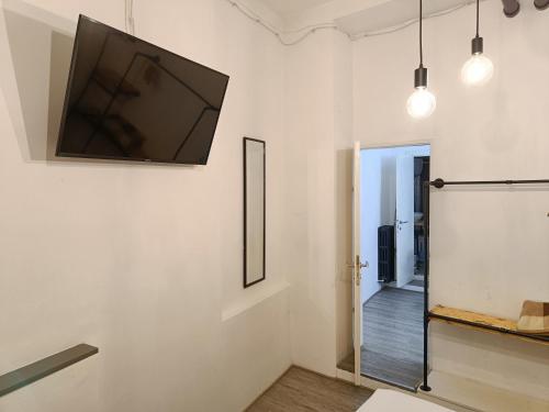 Una sala de estar con un televisor de pantalla plana en la pared. en Umbrian Concierge - Factory House La Viola, en Perugia