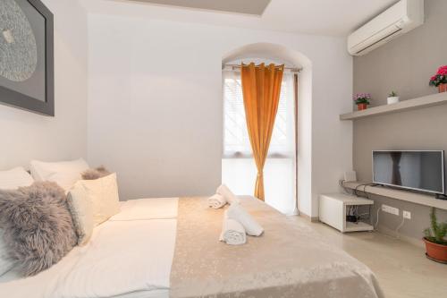 - une chambre blanche avec un lit et une télévision dans l'établissement Rony studio, à Split