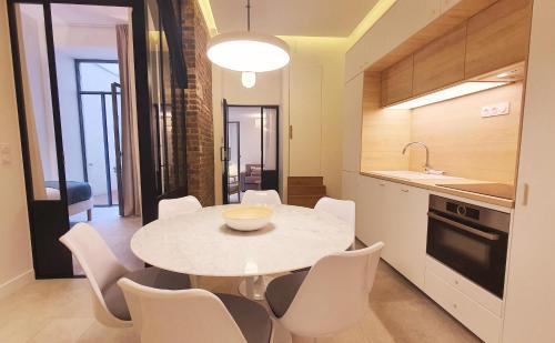 a kitchen and dining room with a white table and chairs at Charles V in Paris
