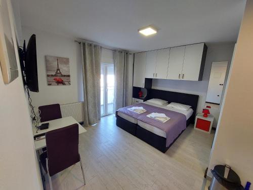 a bedroom with a bed and a desk and a television at Apartments Daniel in Vodice
