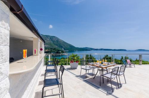 a table and chairs on a balcony with a view of the water at Apartments Sandito in Mlini