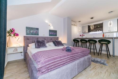 a bedroom with a large bed and a kitchen at Apartments Sandito in Mlini