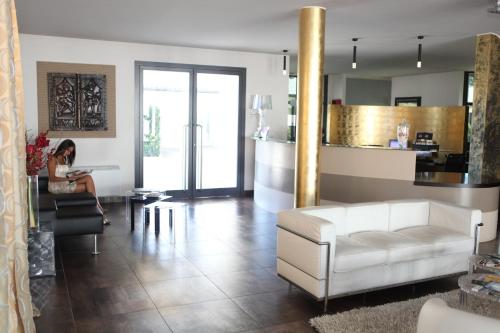 a woman sitting in a chair in a living room at OneMhotel in San Paolo