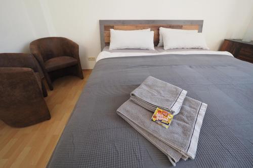 a bedroom with a bed with a blanket and a chair at Haus Felsenpost in Stadt Wehlen