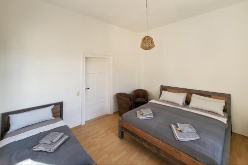 a bedroom with two beds and a chair in it at Haus Felsenpost in Stadt Wehlen