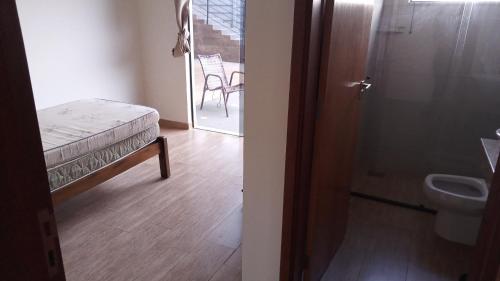 Cette chambre comprend un lit et une salle de bains pourvue de toilettes. dans l'établissement Pirassununga, SP - Casa 3 suítes em condomínio RURAL - 06 hóspedes Confortáveis, à Pirassununga