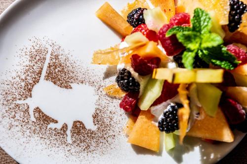 a plate of food with fruit and powdered sugar at Londiningi Guesthouse in Windhoek