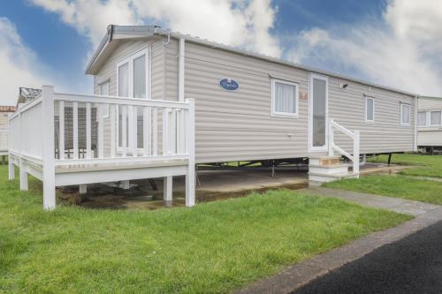 a mobile home with a white porch and stairs at Marine Holiday Park in Rhyl
