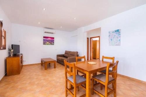 a living room with a table and chairs and a couch at S'Hort Can Capità in Ariany