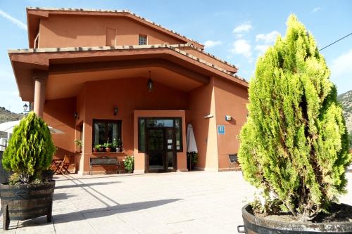 uma casa com duas árvores em frente em Hotel Valdevécar em Albarracín