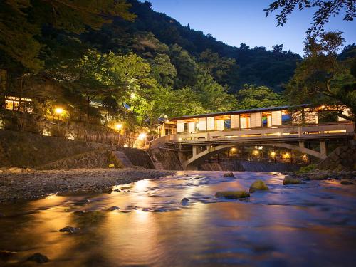 een trein die 's nachts een brug over een rivier oversteekt bij Arima Onsen Gekkoen Korokan in Kobe