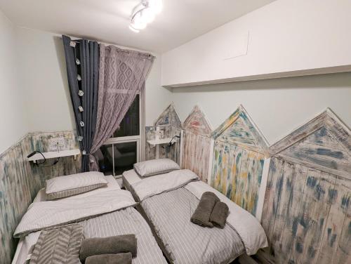 two beds in a room with a painting on the wall at Sunrise View 2 Bed Apartment Sleeps 4 Spa Bath in Bridlington