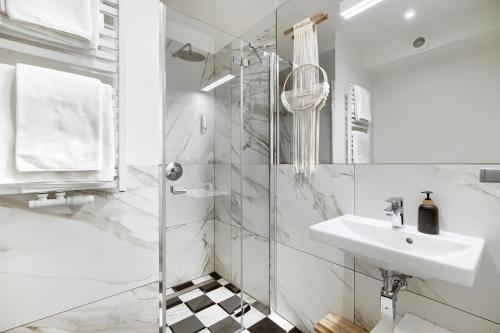 a white bathroom with a sink and a shower at Pałac Pakosław in Pakosław