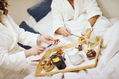 a group of people in bed with a tray of food at Pałac Pakosław in Pakosław